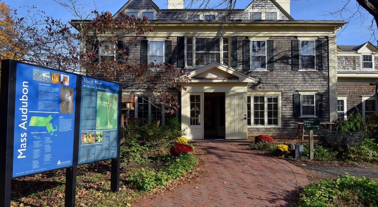 A photograph of a headquarters building and an informational kiosk, with a brick walkway at center.