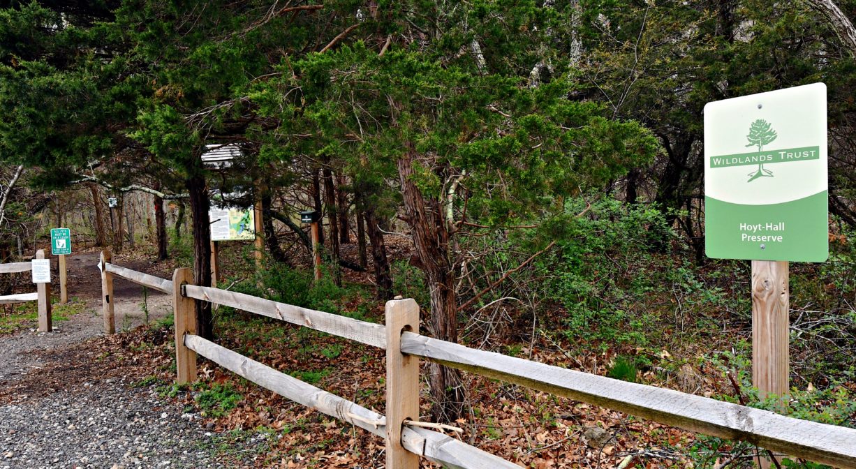 A photograph of a parking area and a property sign.