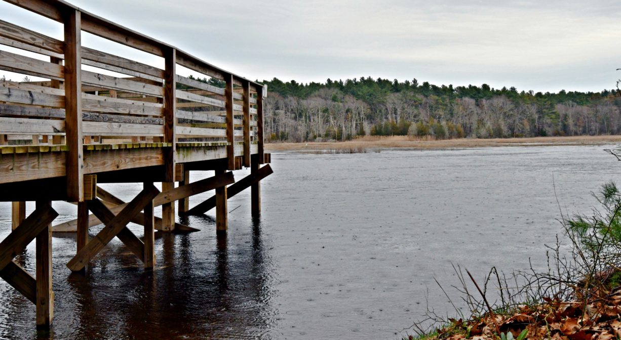 A photograph of a fishing pier on a river.
