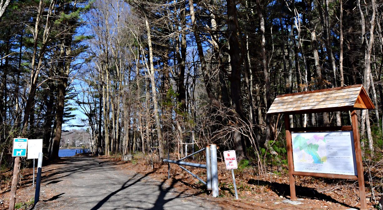 A photograph of a trailhead with signs and an informational kiosk