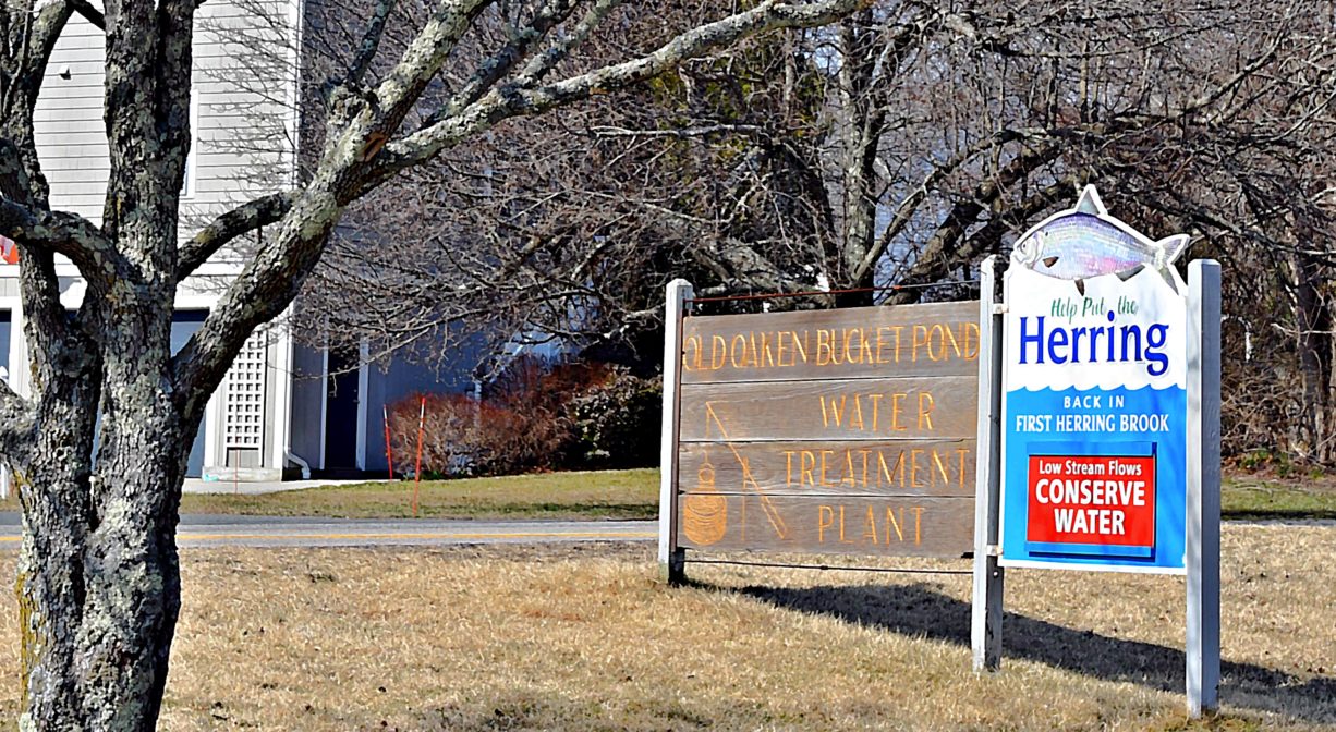 A photograph of a property sign with a tree to one side.