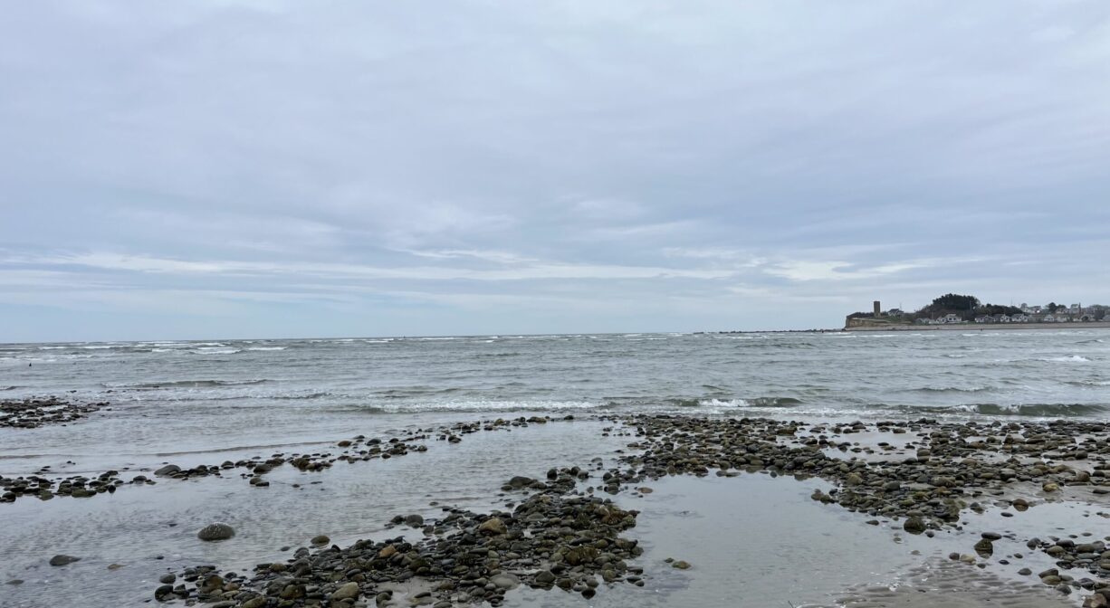 A photograph of the North River mouth with Fourth Cliff in the distance.