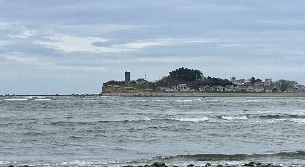 A photograph looking across a river with a cliff and a guard tower in the distance.