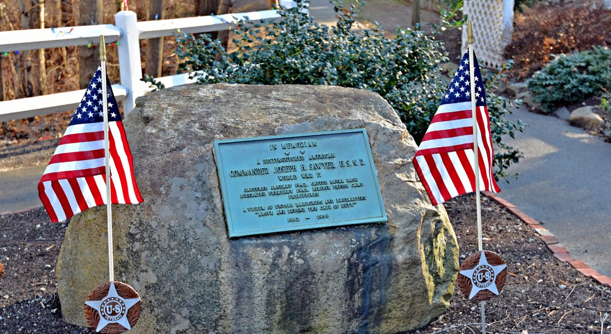A photograph of a memorial with two American flags.