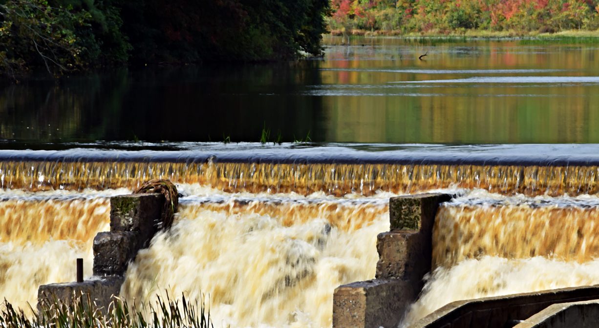 A photograph of a dam and fish ladder on a river.