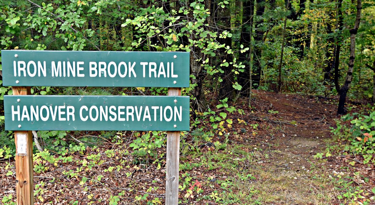A photograph of a trail sign and trailhead.
