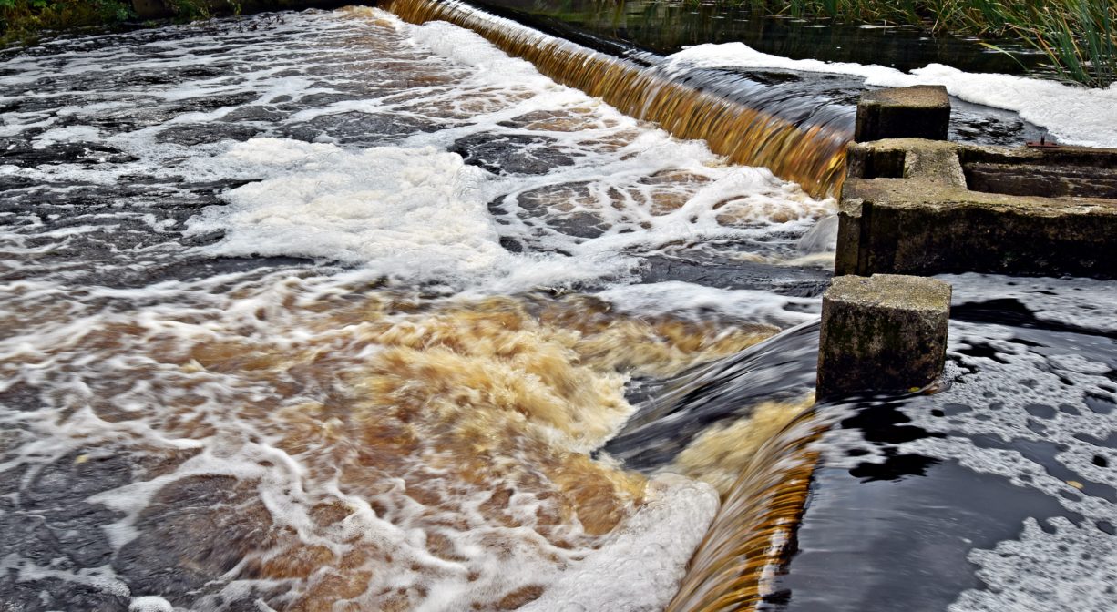 A photograph of water passing over a dam.