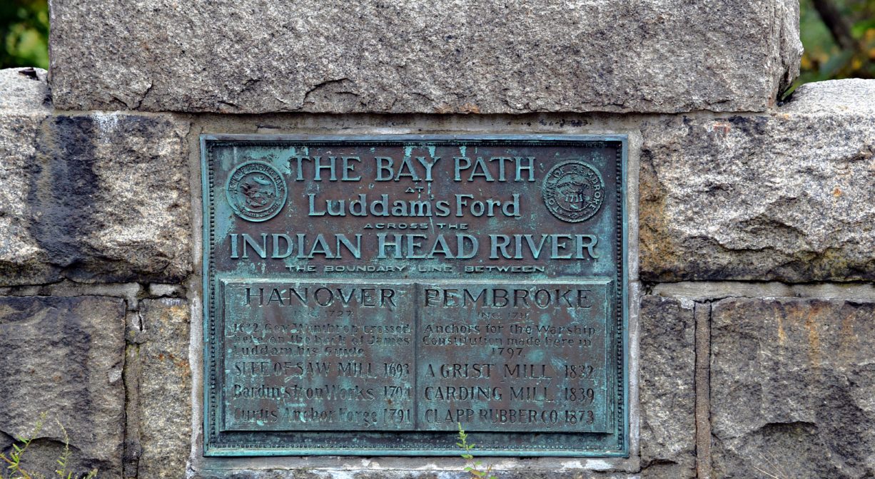 A photograph of a historic marker on a stone bridge.