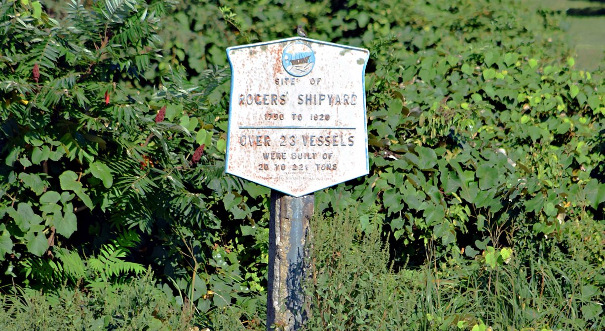 A photograph of a historic sign in a green area.