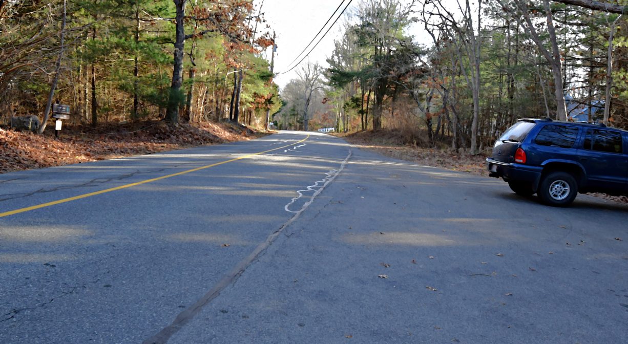 A photograph of a parking area beside a roadway.