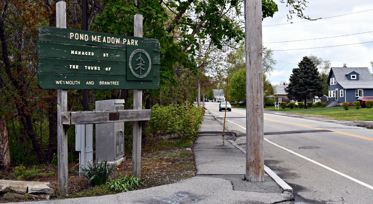 A photograph of a park entrance and property sign.