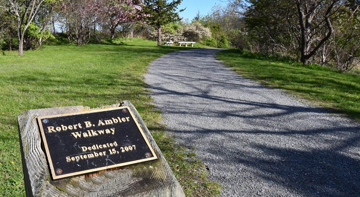 A photograph of a gravel trail with a marker.