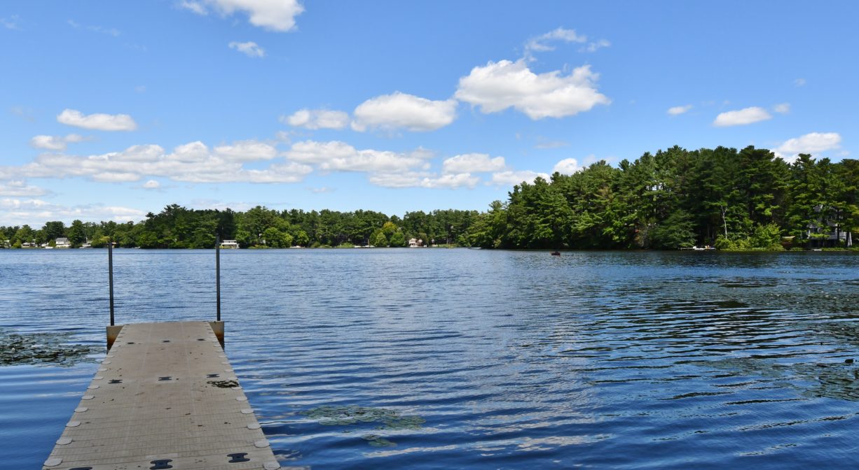 A photograph of a fishing pier extending into a pond.