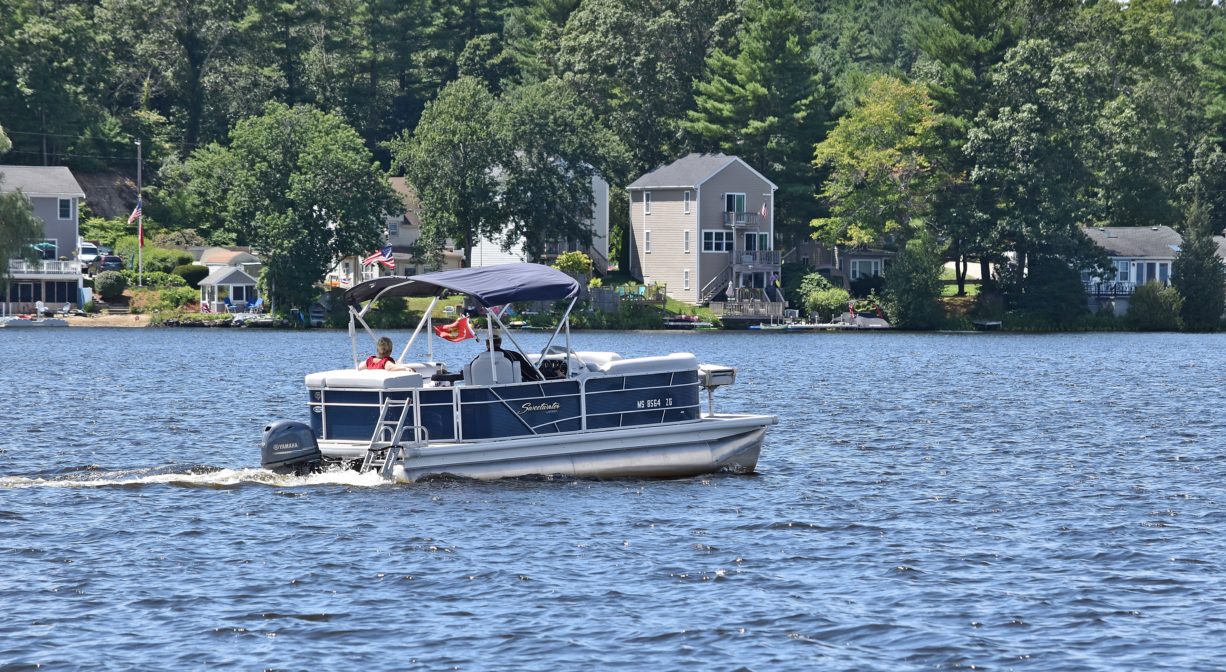 A photograph of a pontoon boat on a pond.