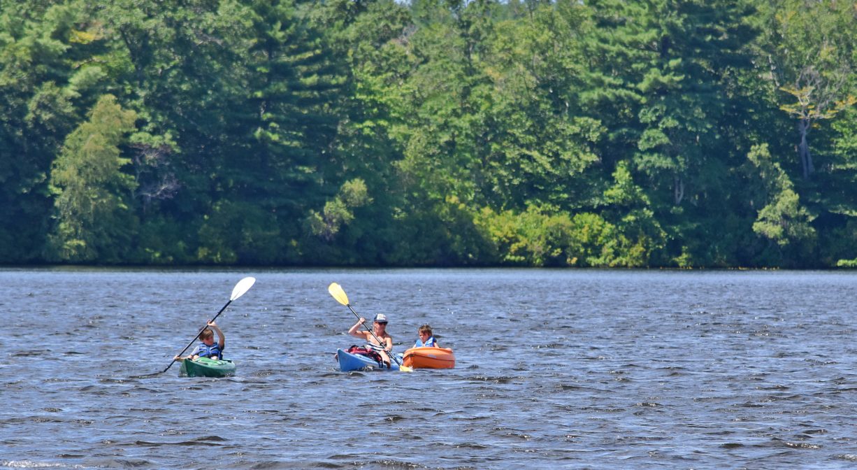 A photograph of kayakers on a pond.