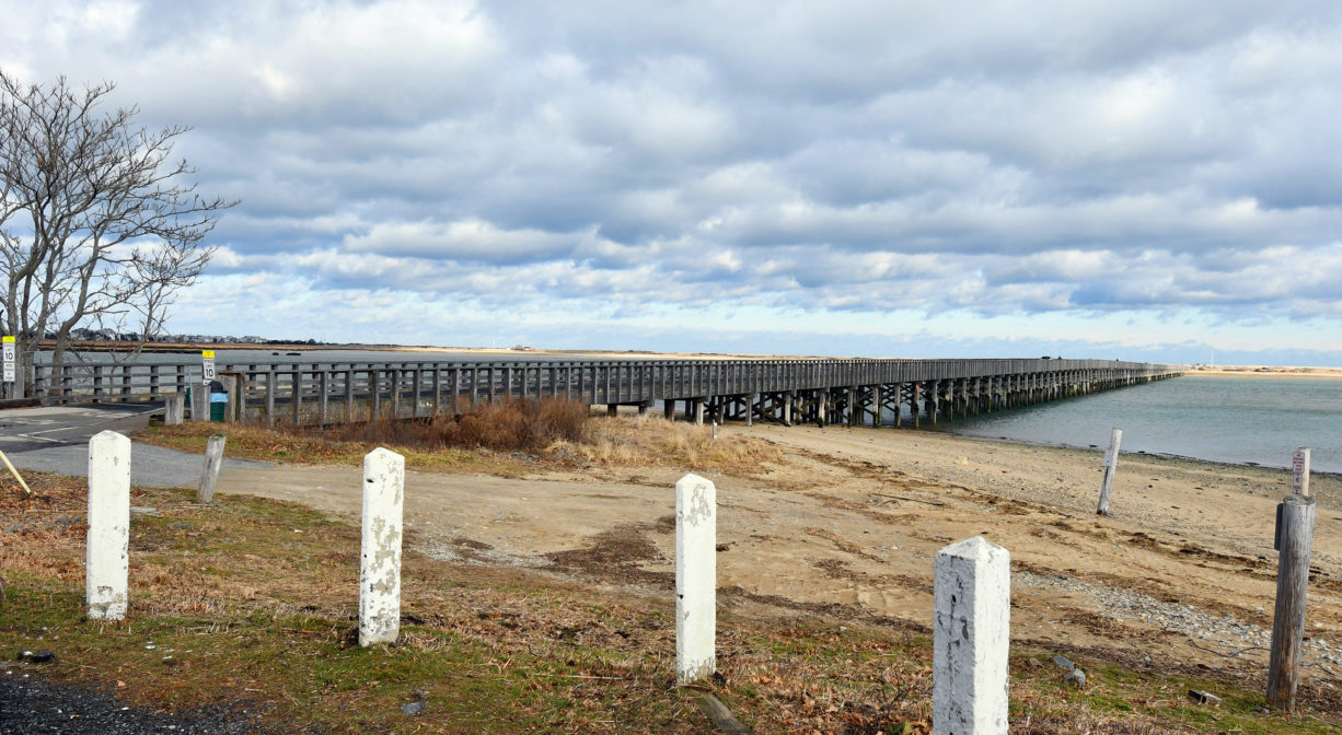 A photograph of a long wooden bridge and a bay.