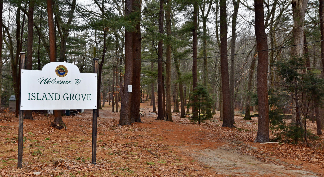 A photograph of a property sign in a wooded setting.
