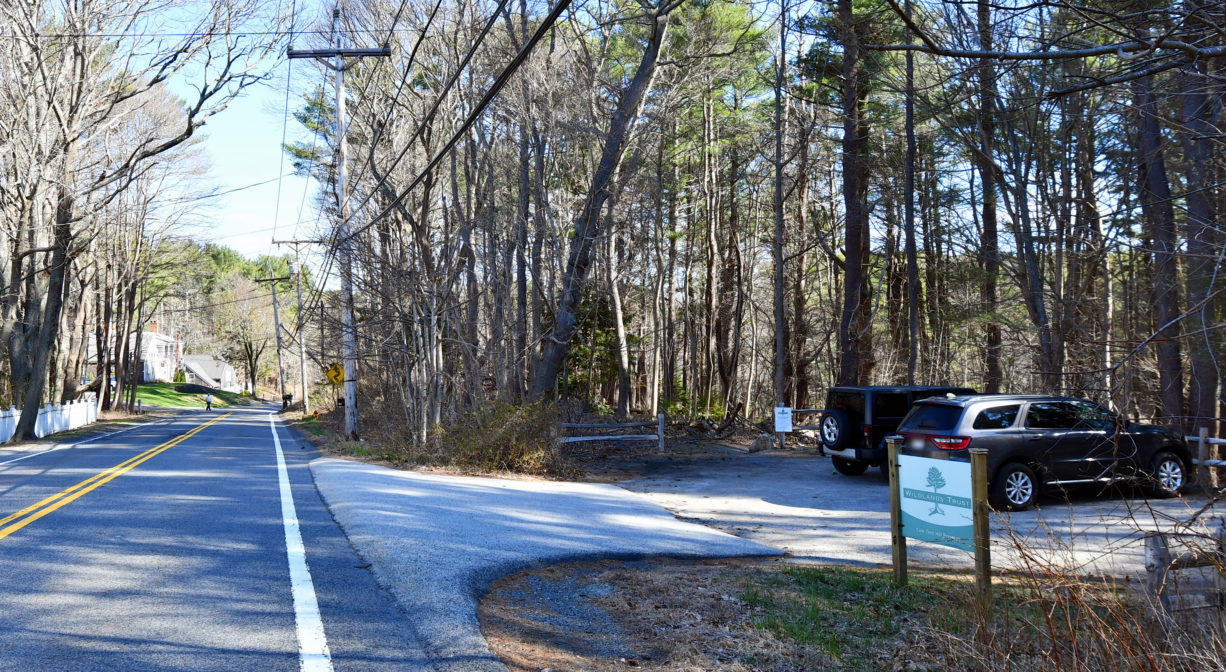 A photograph of a parking area beside a roadway.
