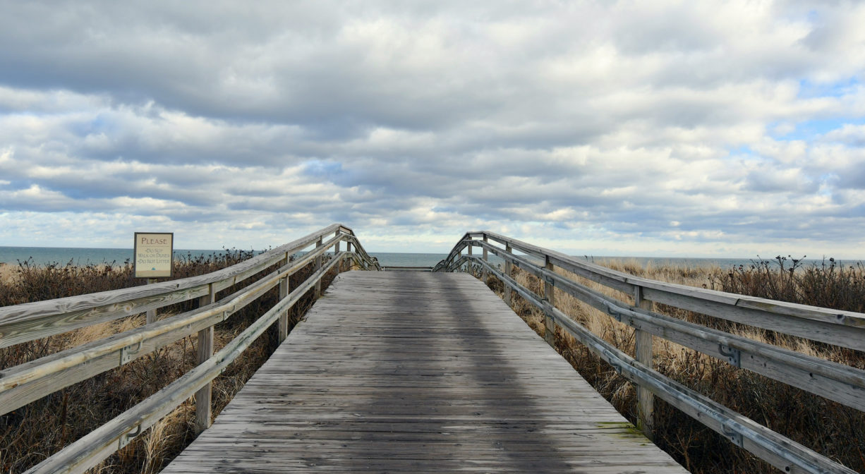 A photograph of wooden plank entrance walkway to a beach.