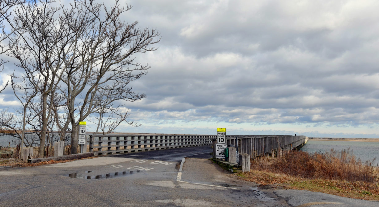 A photograph of a long wooden bridge over a bay.