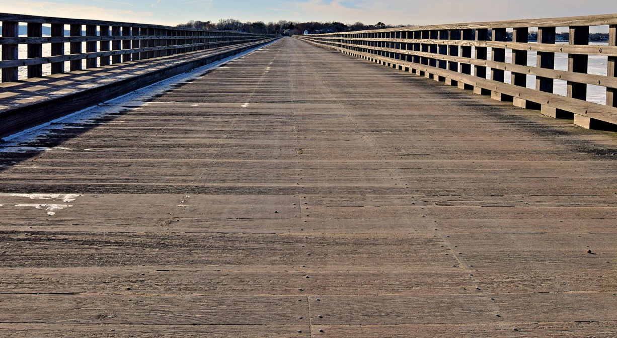 A photograph of a long, wide wooden bridge.