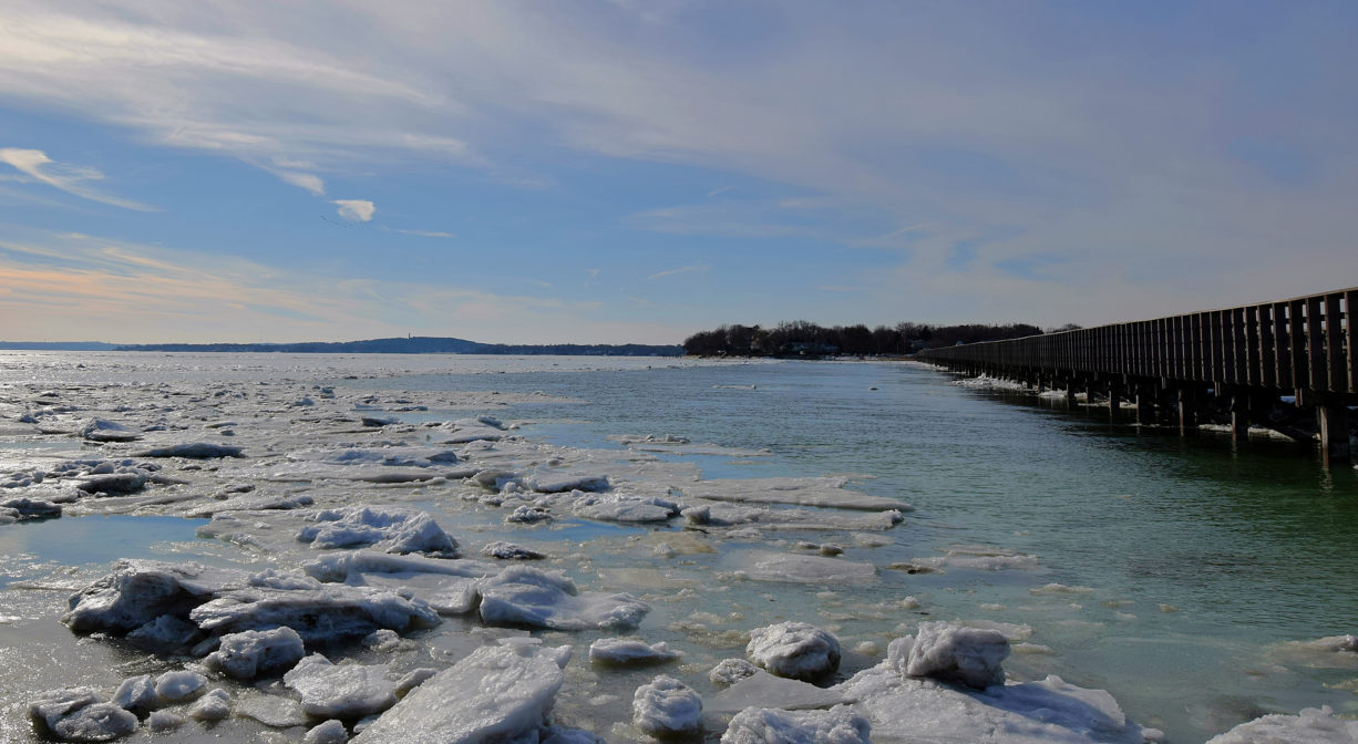 A photograph of a bay with rocks and blue sky.