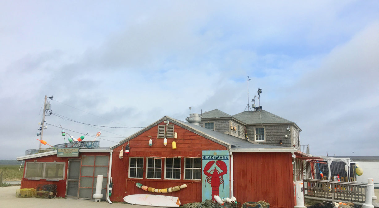 A photograph of a red wooden building with nautical decor.