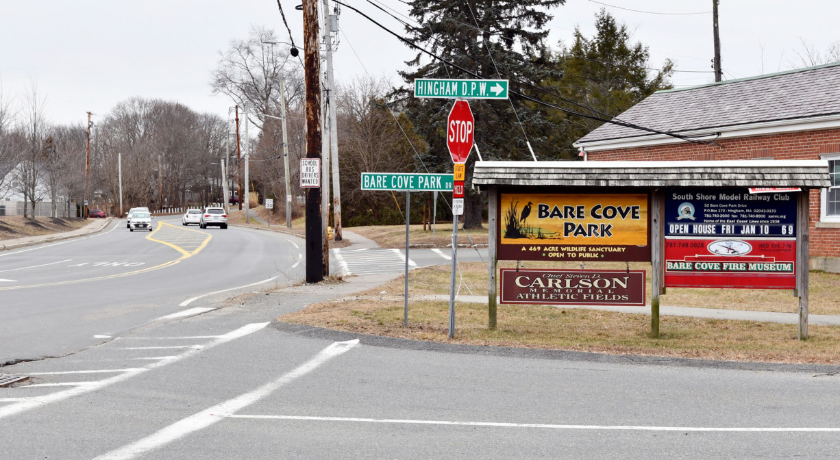 A photograph of a property sign beside an intersection.