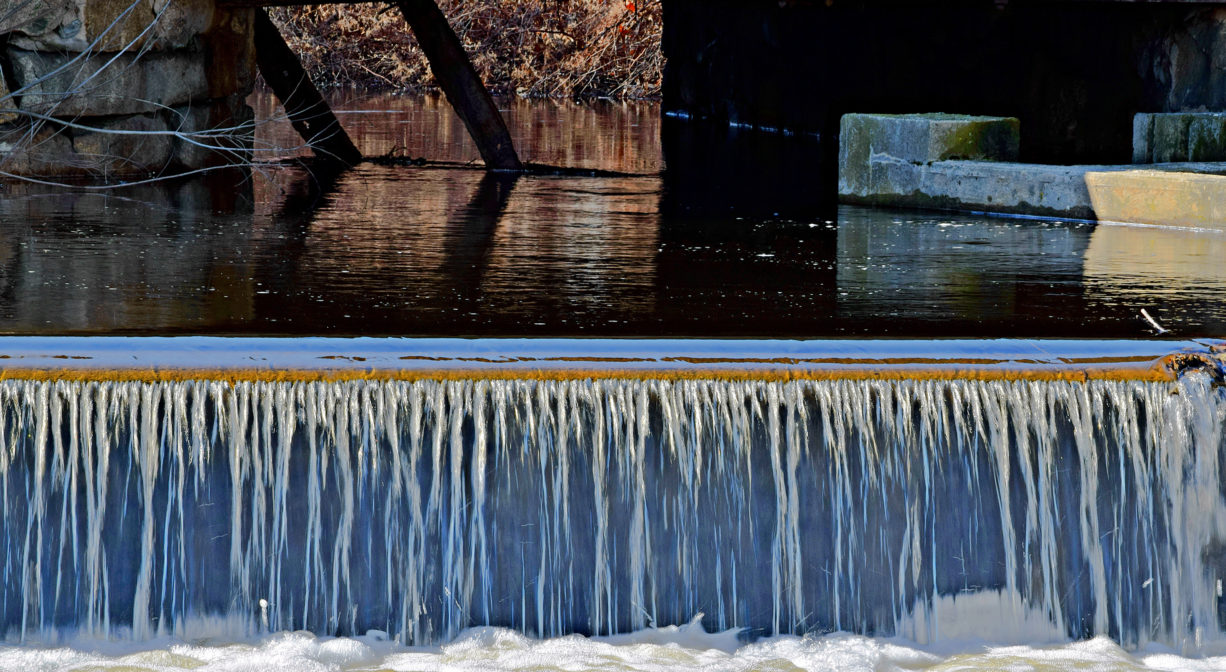 A photograph of water flowing over a dam.