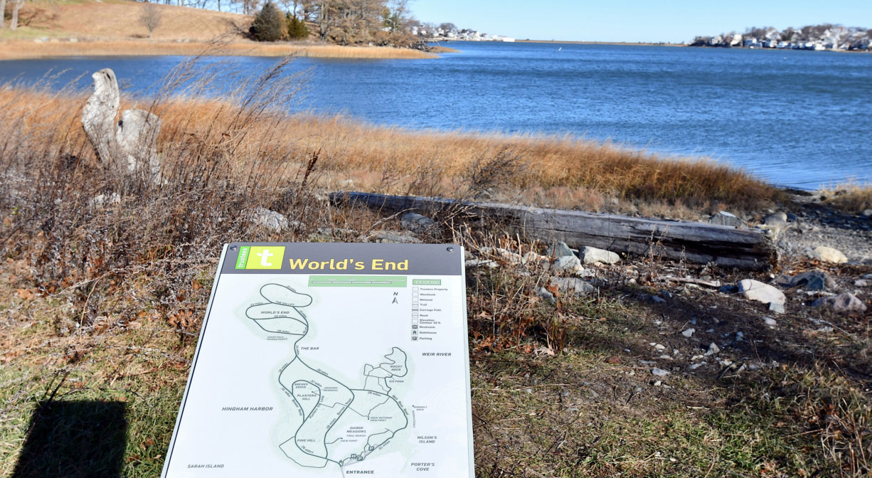A photograph of a trail map overlooking the water.