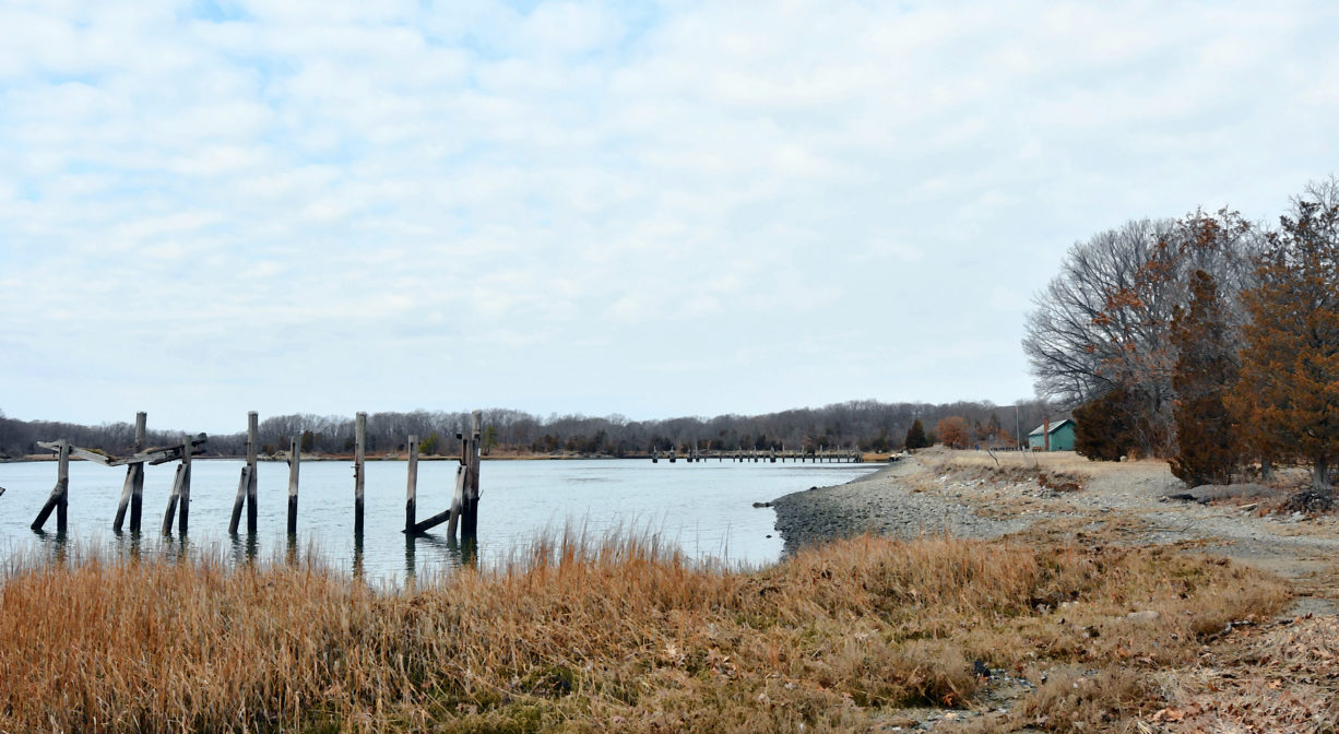 A photograph of a river with the remains of a pier.