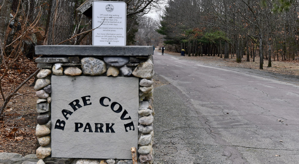 A photograph of a trail with a property sign on one side.