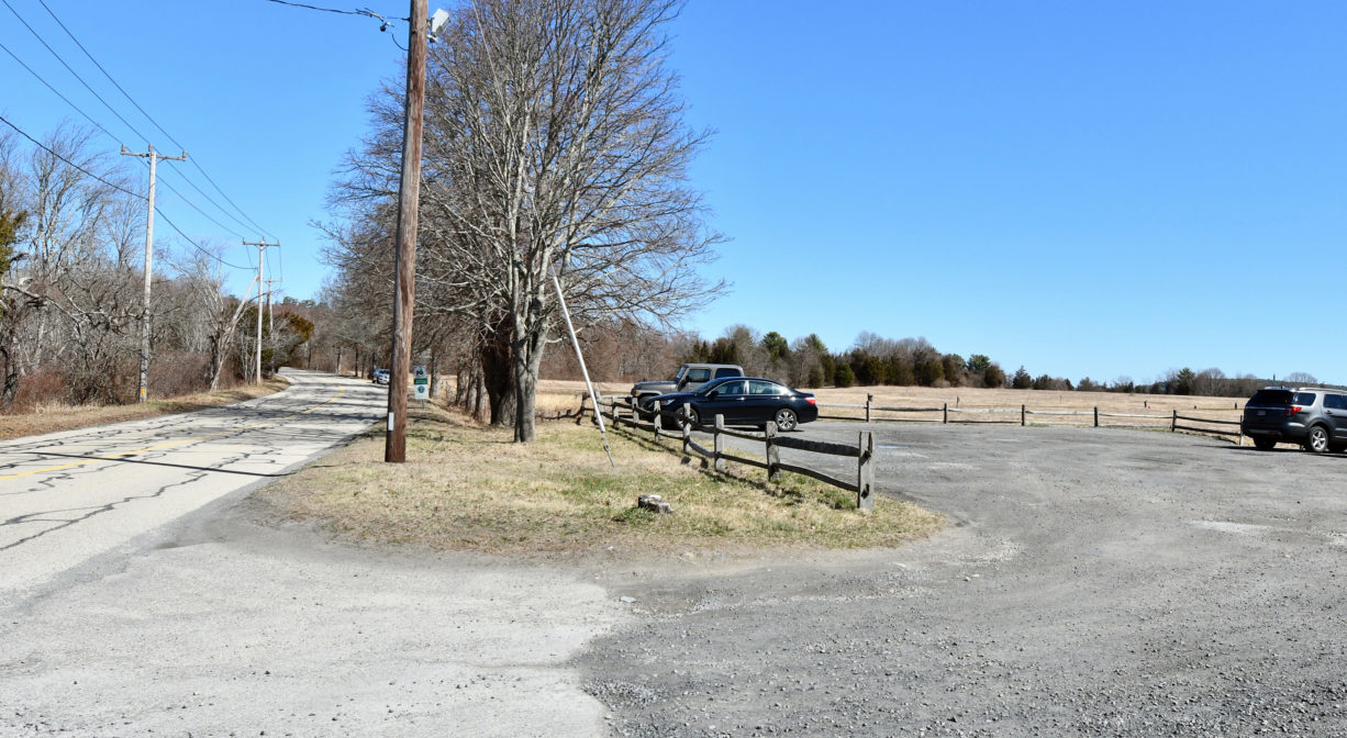 A photograph of a large unpaved parking area.