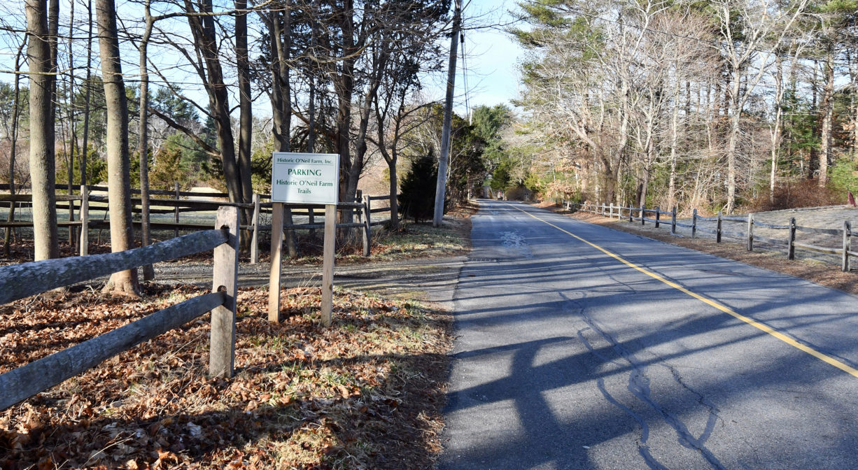 A photograph of a property entrance and a parking area.