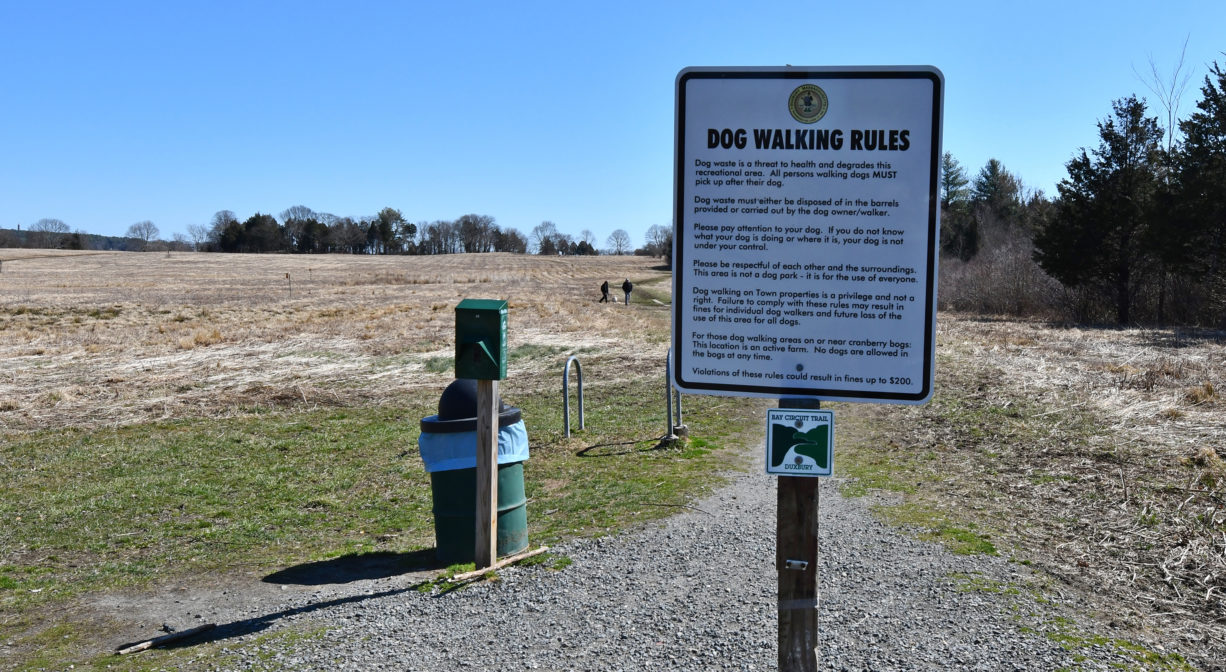 A photograph of a property sign with dog walking rules.