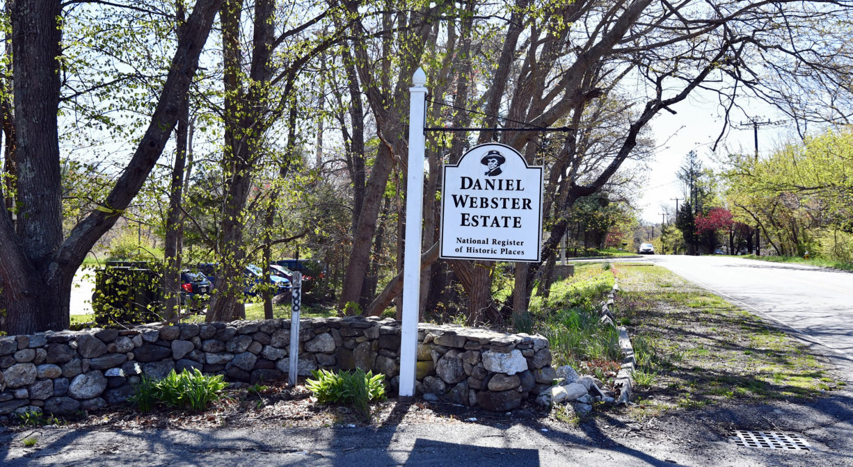 A photograph of a property sign and entrance road.