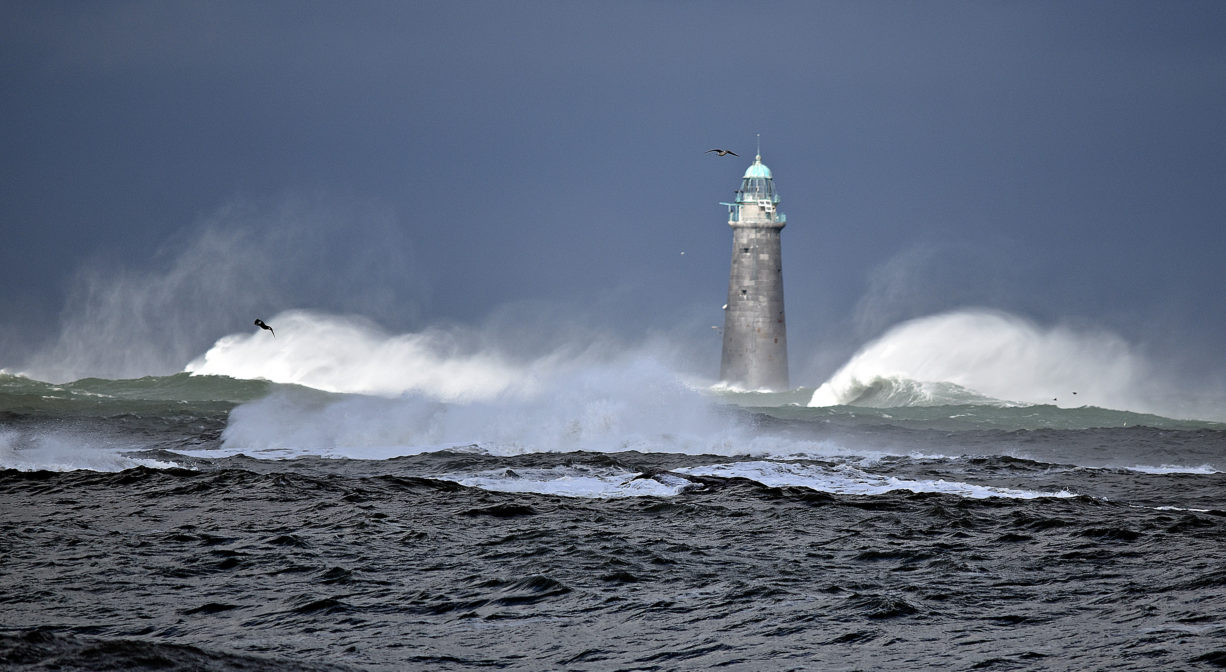 A photograph of a lighthouse with roaring surf.