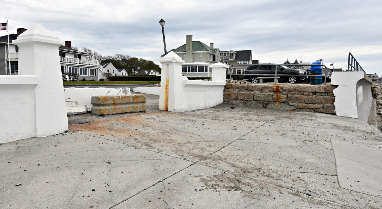 A photograph of the entrance to a beach, with a poured concrete area.