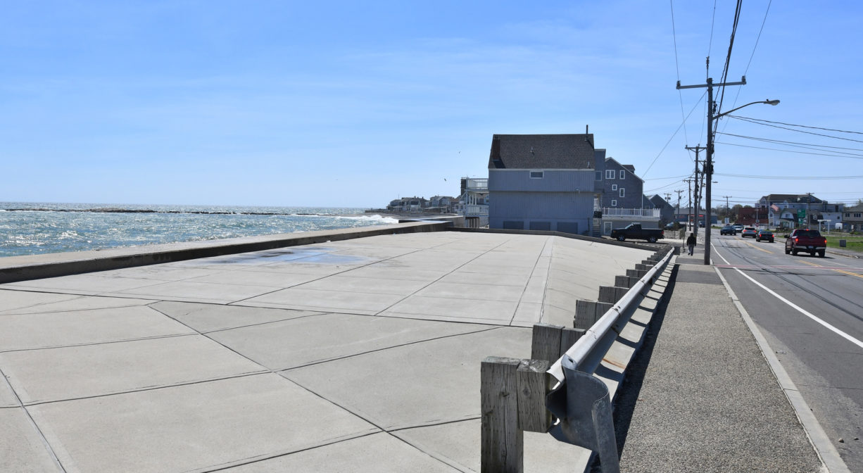 A photograph of a flat concrete area beside a seawall.