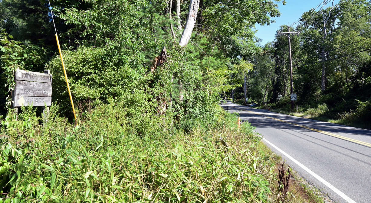 A photograph of a property sign beside a roadway.