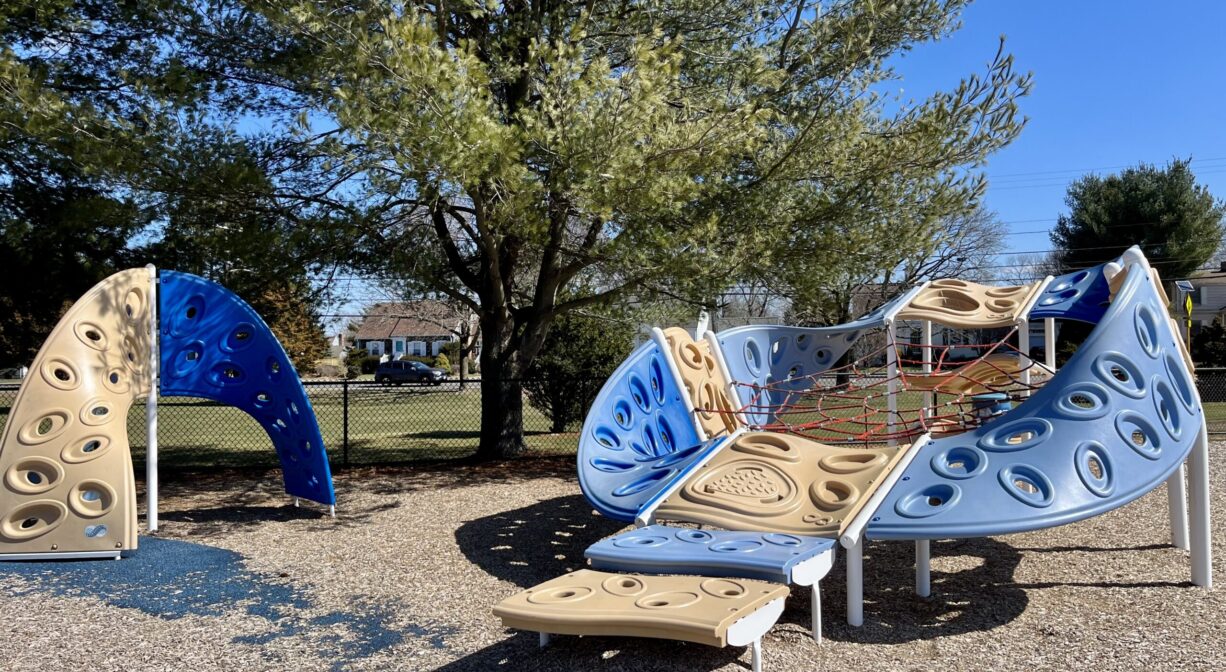 A photograph of two blue and gold climbing structures within a playground.