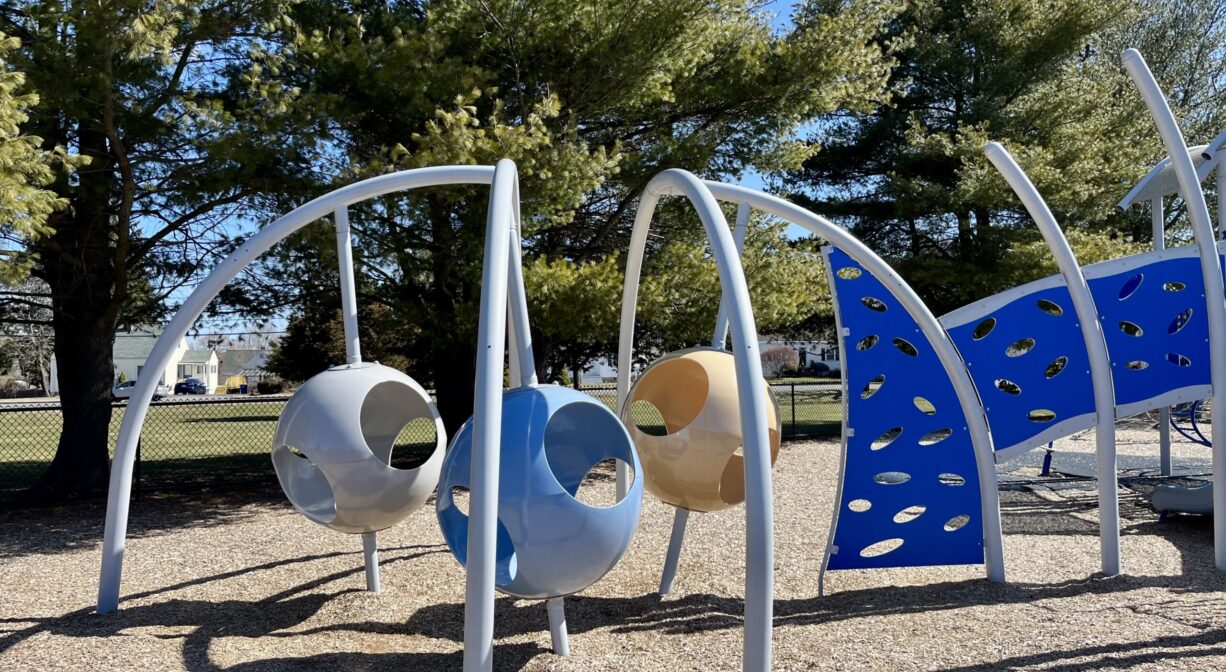 A photograph of a space-age play structure within a playground.