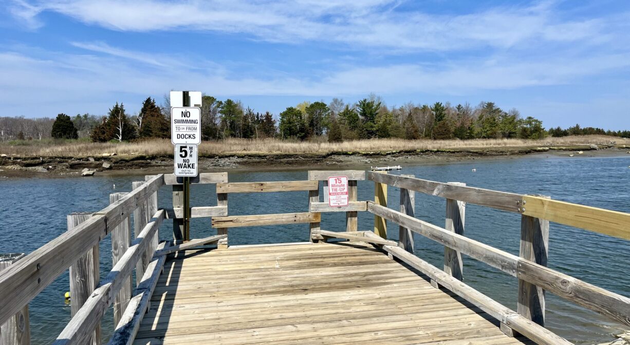 A photograph of a wooden fishing pier on a river.