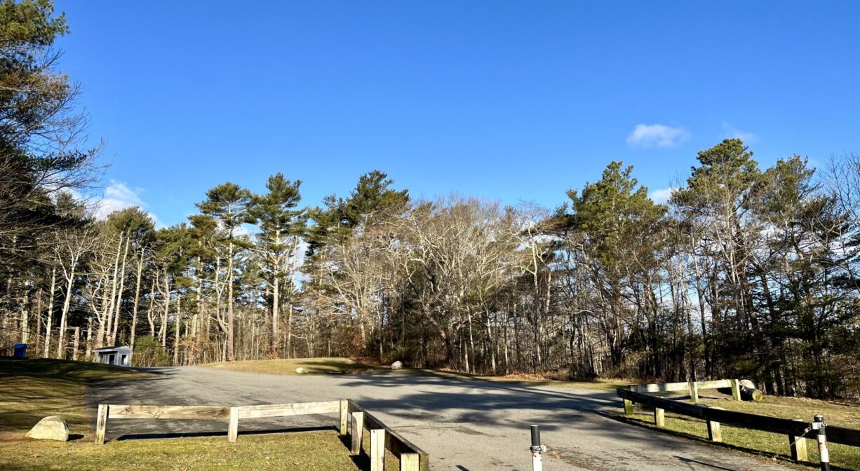 A photograph of a parking area on a grassy hill.