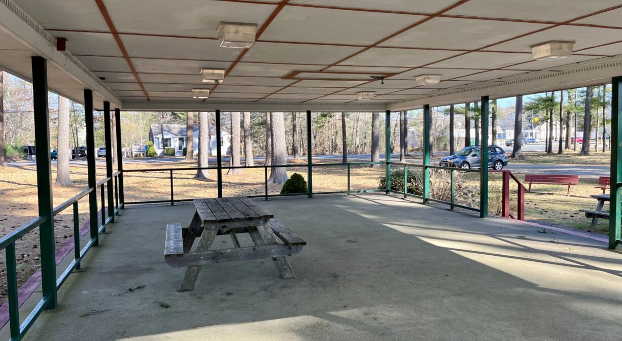 A photograph of the interior of a picnic pavilion, with one picnic table.