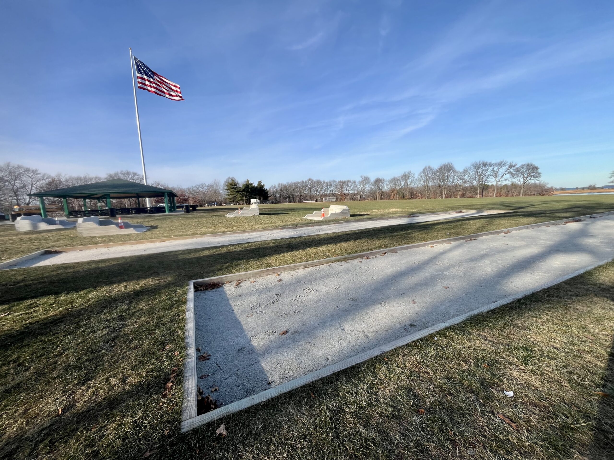 A photograph of horseshoe and bocce courts in a park.